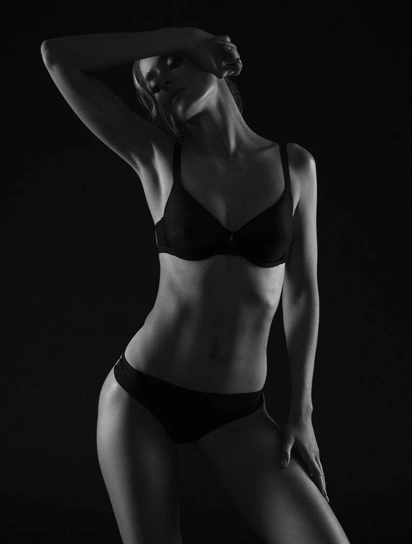 woman in a black underwear set, posing with one arm above her head - Laser Treatments in Toronto, ON